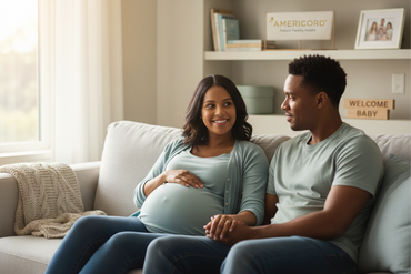 Pregnant couple smiling on couch