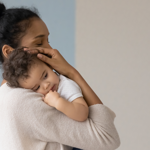A mother gently cradling a baby in her arms.